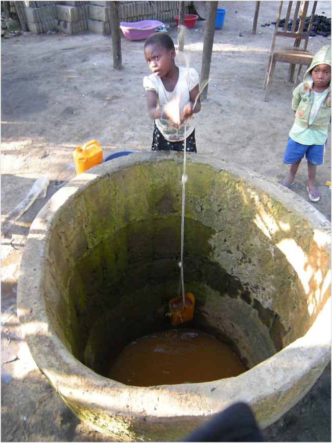 Girl in Icidua drawing water from an open well; mangroves reduce saltwater intrusion into the water table